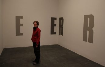 Moderne Kunst in der Arts Gallery (Kunst an der Wand, davor kunstsinnige Betrachterin) In der Arts Gallery